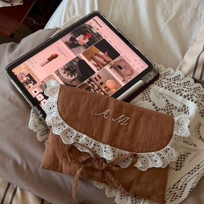 Handmade brown quilted letter pouch with white lace ruffles and floral lace embroidery, available as a cosmetic pouch, A5 book sleeve and padded iPad sleeve.
