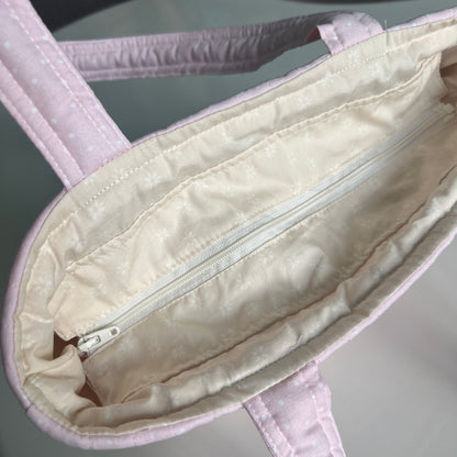 Close-up of a white baby carrier with a zipper on a gray background